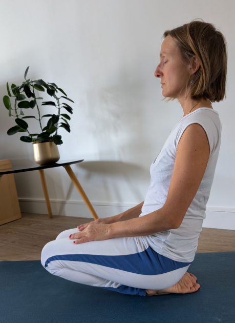 Une femme en posture d'étirement des chevilles en Yin Yoga, une pratique axée sur le relâchement profond.