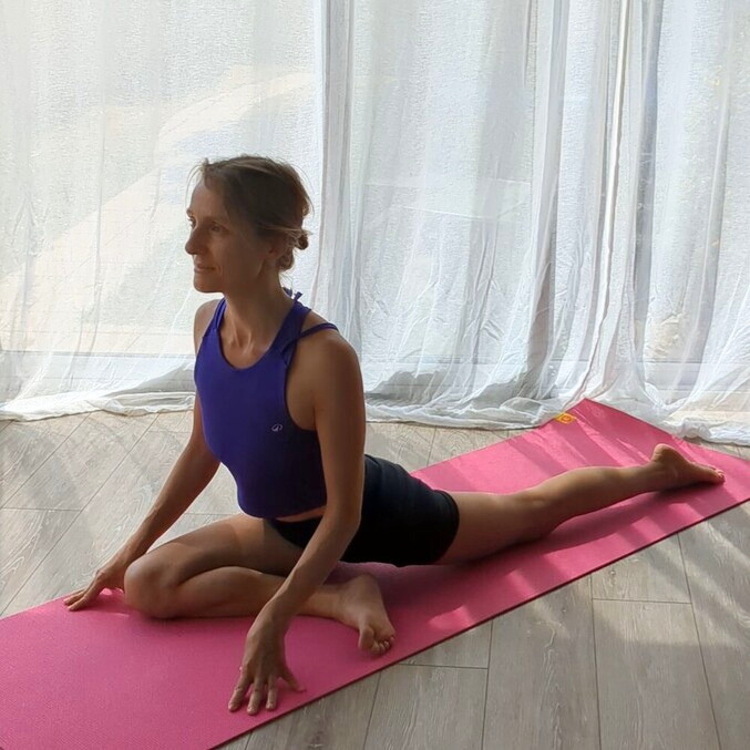 Atelier de yoga à Villejuif : ouverture des hanches et libération émotionnelle. La pratiquante réalise la posture de la sirène (Eka Pada Rajakapotasana) sur un tapis de yoga.